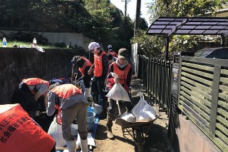 土嚢をねこ車(一輪車)に入れて運びます。